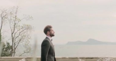 Genç damat düğün töreninde lüks çiçek buketlerinin yanında yürür.