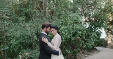 Düğünde Isola Del Garda 'da yemyeşil alanda sarılan genç çift..