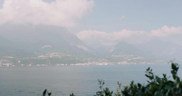 Céu azul com nuvens brancas roxas acima do lago Garda à noite — Vídeo de Stock