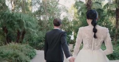 Genç evli çift Isola Del Garda 'da yolda yürür ve kameraya bakar..