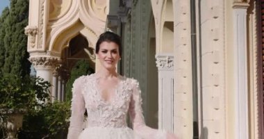 Beyaz gelinlikli genç kadın egzotik adanın balkonunda duruyor.