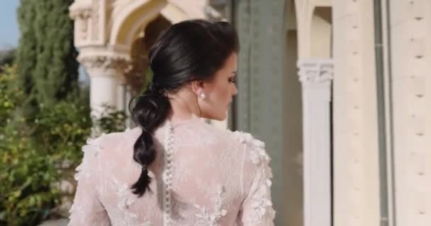 Young woman in white wedding dress stands on the balcony on exotic island — Video Stock