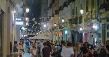 İnsanlar Las Fallas 'ı kutlamak için yaya caddesinde yürüyor.