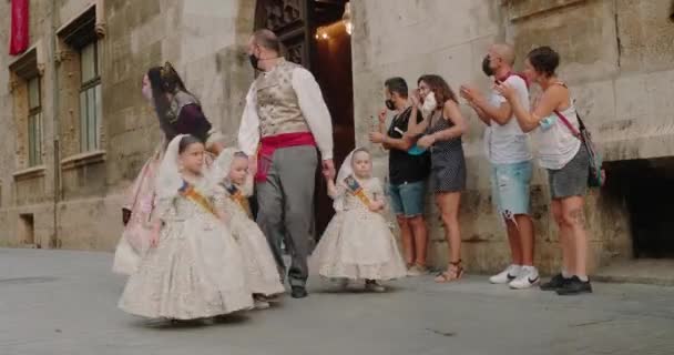 Vater mit drei Töchtern laufen kostümiert auf Straße an Menschen vorbei, die klatschen — Stockvideo