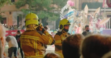 İtfaiyeciler sokakta durup yangını söndürmeye hazırlanıyorlar.