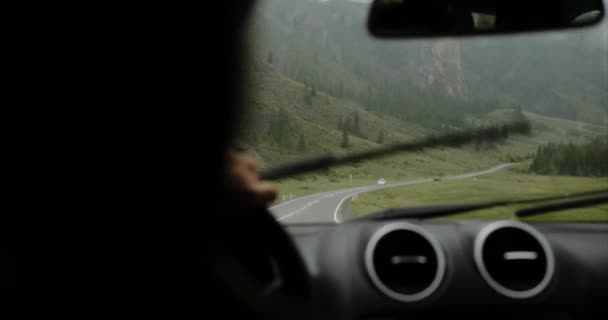 Sopir pergi dengan mobil pada hari hujan di Altai, gunung di latar belakang — Stok Video