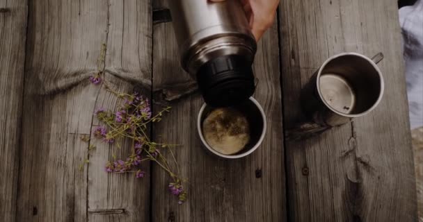 Жінка робить трав'яний чай, наливаючи гарячу воду в чашки — стокове відео