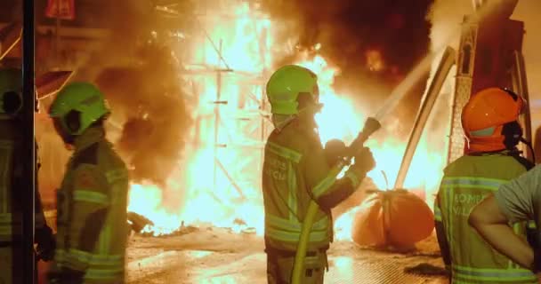 Feuerwehrleute beobachten brennende Puppenfiguren — Stockvideo