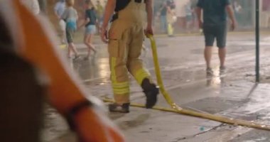 İtfaiyeci yanan heykelleri söndürdükten sonra yangın hortumunu aldı.