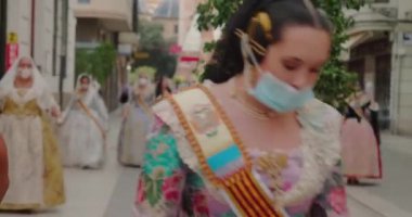 Uzun folklor elbiseli kadınlar insanları alkışlayarak yolda yürürler.