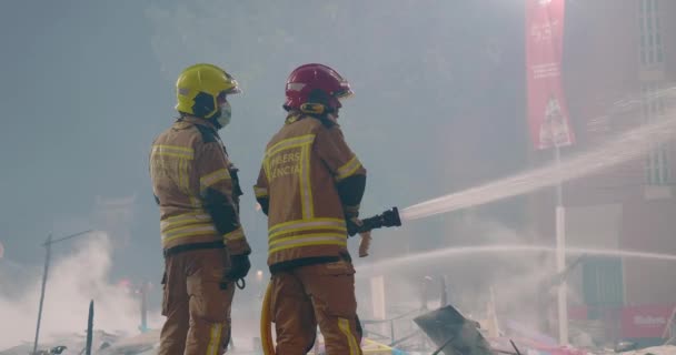 Firefighters put out fire remaining from burning figures — Vídeo de Stock