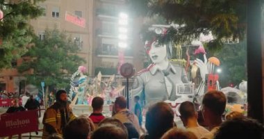 İnsanlar sokakta durup oyuncak bebeklerin heykellerini yakmaya hazırlanıyorlar.