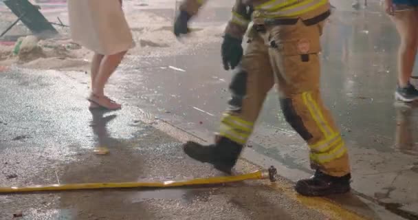 Firefighter takes firehose after putting out burning statues — Vídeos de Stock