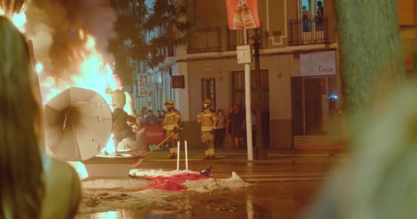 Bomberos observan las figuras ardientes de muñecas — Vídeo de stock