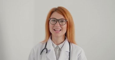 Kadın terapist gülümser ve gözlüğünü çıkararak tavsiye verir. Kızıl saçlı doktor hastalara çevrimiçi danışmanlık yapıyor. Beyaz önlüklü bayanın her zamanki çalışma günü.