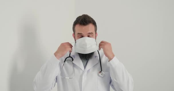 Hombre Médico Pone Máscara Médica Cara Mira Cámara Hombre Serio — Vídeos de Stock