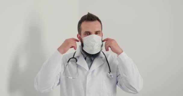 Erkek Doktor Tıbbi Maske Takıp Kameraya Bakıp Gülümsüyor Klinikte Internet — Stok video