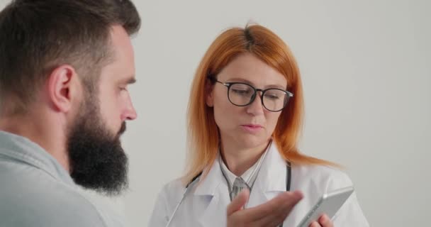 Femme Médecin Avec Comprimé Dans Les Mains Consulte Patient Masculin — Video