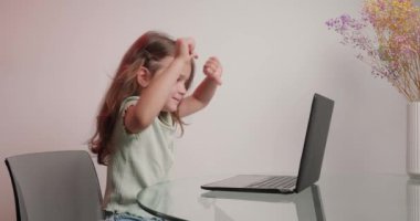 Tatmin olmamış bir kız bilgisayarla arkadaşlarıyla görüntülü konuşmaktan hoşlanmaz. Uzun saçlı şirin bir çömez vazoyla cam masada oturuyor.