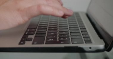 Kadın iş yerinde yeni web sitesi için yazı yazmak için laptop kullanıyor. Bayan çalışanın elleri ofis içinde modern cihazın klavyesine basıyor.