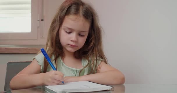 Petite Écolière Aux Cheveux Longs Assoit Table Écrivant Avec Stylo — Video
