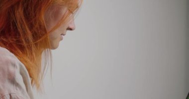 Odaklanmış kızıl saçlı kadın ofisinde oturmuş müdüre göndermek için rapor yazıyor. Kadın çalışan modern dizüstü bilgisayarda çalışıyor. Kromakey yeşil ekran yakın plan.