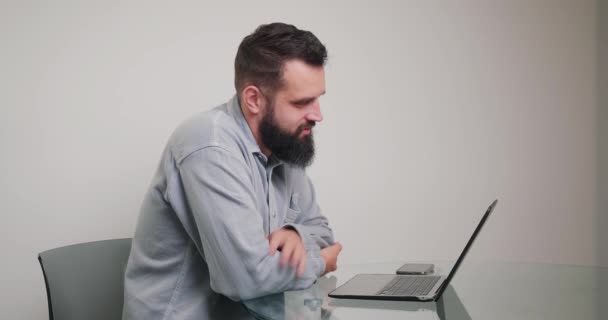 Ein Bärtiger Mann Sitzt Schreibtisch Und Unterhält Sich Laptop Mit — Stockvideo