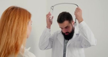 Erkek terapist, bayan hastaya danışmanlık yapıyor ve gülüyor. Sakallı doktor olgun bir kadına steteskobu boynuna geçirmesini tavsiye eder. İnsanın her zamanki çalışma günü.