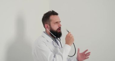 Steteskop taklit eden mikrofonlu doktor ofiste şarkı söyleyip dans ediyor. Genç terapist, öğle tatilinde iş yerinde eğleniyor.