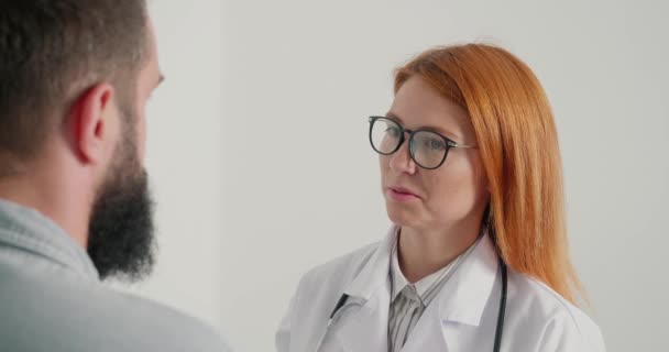Ärztin Berät Männliche Patientin Klinik Praxis Hausärztin Erklärt Älteren Bärtigen — Stockvideo