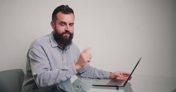 熟练的教练解释说 创建的网站展示了将笔记本电脑的Cromakey绿色屏幕变成相机的例子 留胡子的男人坐在办公室的办公桌前 — 图库视频影像
