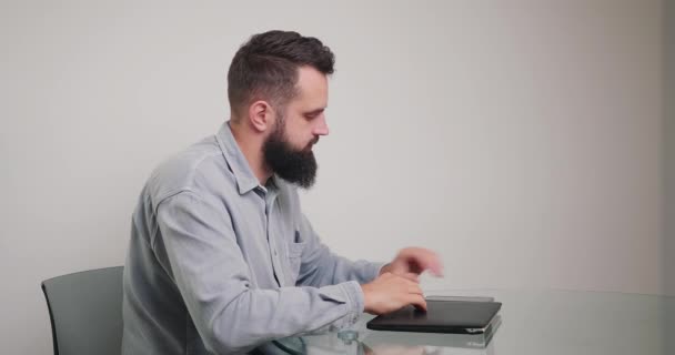 Brodaty Mężczyzna Kończy Rozmowę Telefoniczną Zaczyna Pracować Nad Laptopem Aby — Wideo stockowe