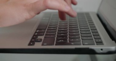 Kadın iş yerinde yeni web sitesi için yazı yazmak için laptop kullanıyor. Bayan çalışanın elleri ofis içinde modern cihazın klavyesine basıyor.