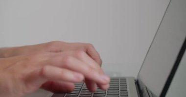 Bayan çalışan, ofiste oturan dizüstü bilgisayarla site için makale yazıyor. Kadınların elleri beyaz arkaplanda cihazın klavyesindeki tuşlara basar
