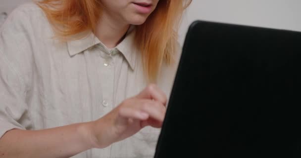 Rödhårig Kvinnlig Anställd Söker Information Laptop Som Sitter Vid Skrivbordet — Stockvideo