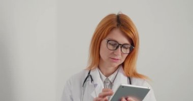 Kızıl saçlı kadın doktor hastayla tanışıyor ve tedaviden sonra gülüyor. Bayan pratisyen doktor randevuda sağlıklı bir adamla buluşurken gülümsüyor.