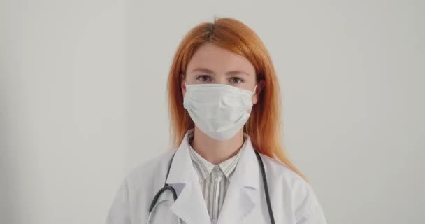Doutora Ruiva Tira Máscara Médica Parece Sorridente Câmera Mulher Alegre — Vídeo de Stock