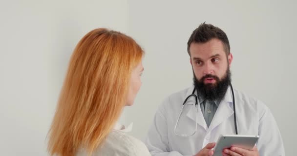 Mężczyzna Lekarz Ogólny Daje Słabe Wyniki Badań Dojrzałej Rudej Kobiecie — Wideo stockowe
