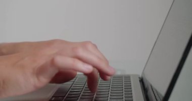 Bayan çalışan, ofiste oturan dizüstü bilgisayarla site için makale yazıyor. Kadınların elleri beyaz arkaplanda cihazın klavyesindeki tuşlara basar
