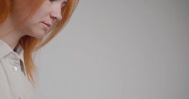 Kızıl saçlı kadın web sitesi içeriği için yeni fikirler düşünüyor. Genç bayan çalışan dizüstü bilgisayarda çalışıyor. Ofiste yazı yazıyor. Beyaz arka planda yakın plan.