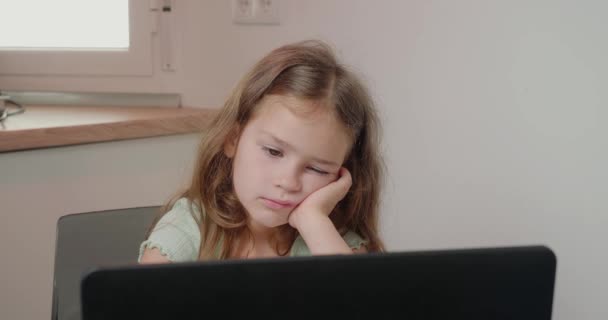 Sıkılmış Kız Masada Oturup Dizüstü Bilgisayar Esnemelerle Öğretmenin Açıklamasını Dinliyor — Stok video