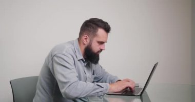 Klavyede hata yapan sinirli bir adam hızlı yazar. Uzun sakallı kızgın serbest çalışan, odadaki masada oturan elektronik cihaza isabet etti.