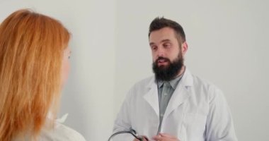 Erkek terapist bayan hastaya danışmanlık yapıyor. Sakallı doktor olgun bir kadına steteskobu boynuna geçirmesini tavsiye eder. İnsanın her zamanki çalışma günü.