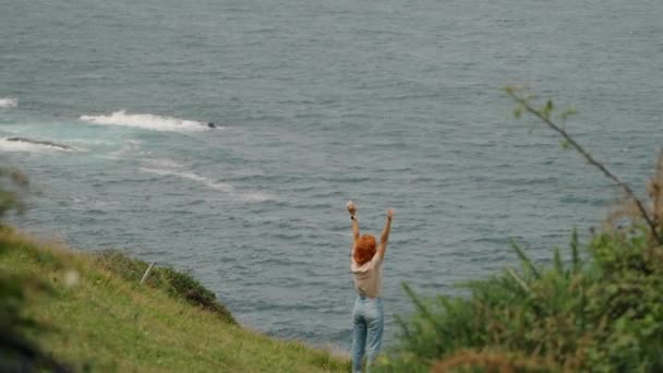 Redhead Woman Raises Hands Standing Hill Top Edge Lush Greenery — Wideo stockowe