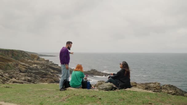 친구들은 구름낀 절벽의 바다와 사이에서 의사소통을 즐긴다 관광객들은 바람부는 날느린 — 비디오
