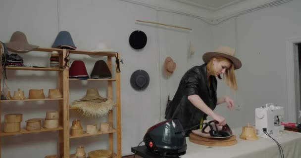 Focused Blonde Woman Straightens Material Felt Hat Brim Wooden Mold — Stockvideo