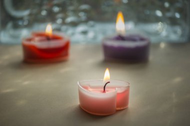 Üç renkli üç kalp mumu yakıldı ve güzel kokulu bir koku yayıldı..