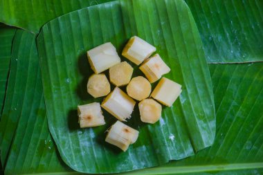 Soyulmuş baston, muz yapraklarıyla parçalara ayrılmış..