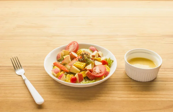 果物と野菜のサラダ カニの白いプレートに棒 木製の床にサラダドレッシングのカップ — ストック写真