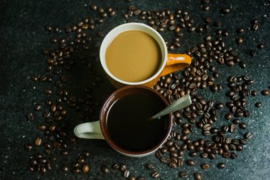 İki fincan kahve. Siyah arka planda iki farklı tat. Üst görünüm.